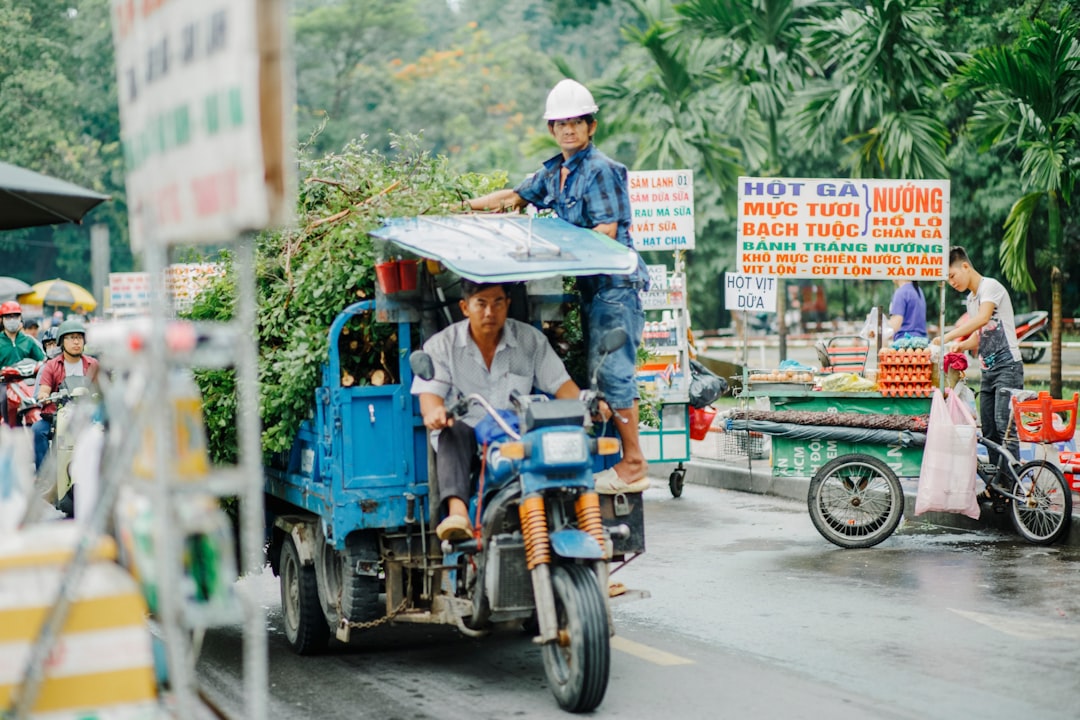a man riding a motorcycle with a load of trees on the back of it