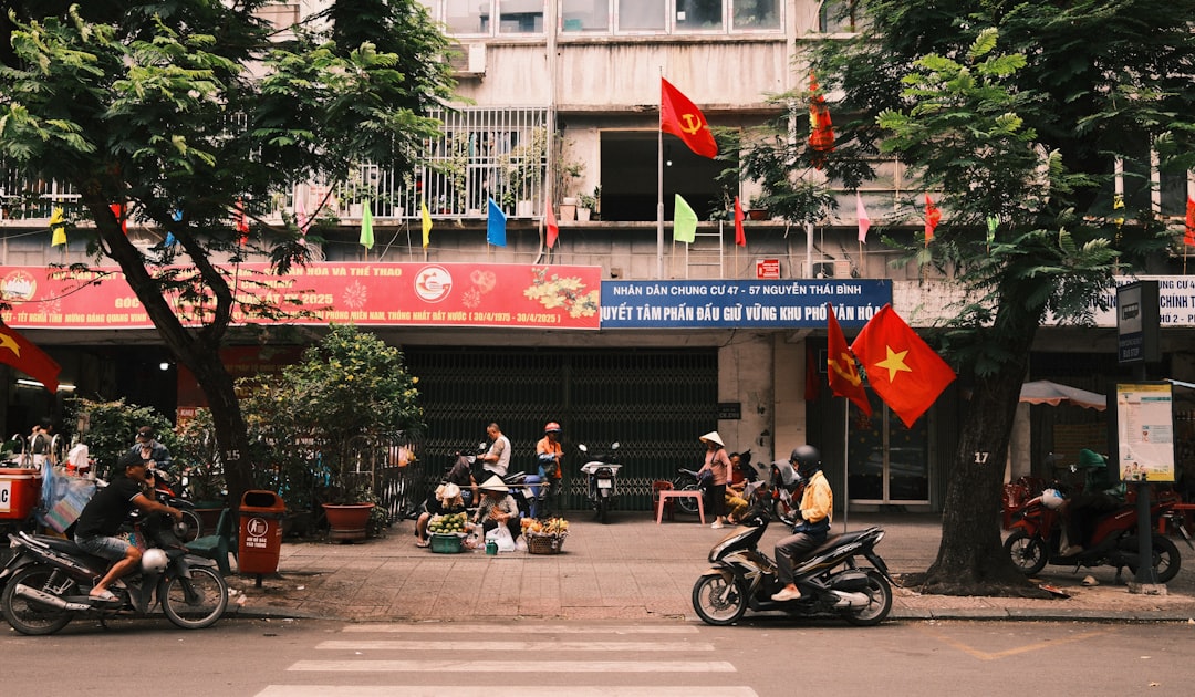 Motorbikes parked on a street with vietnamese flags