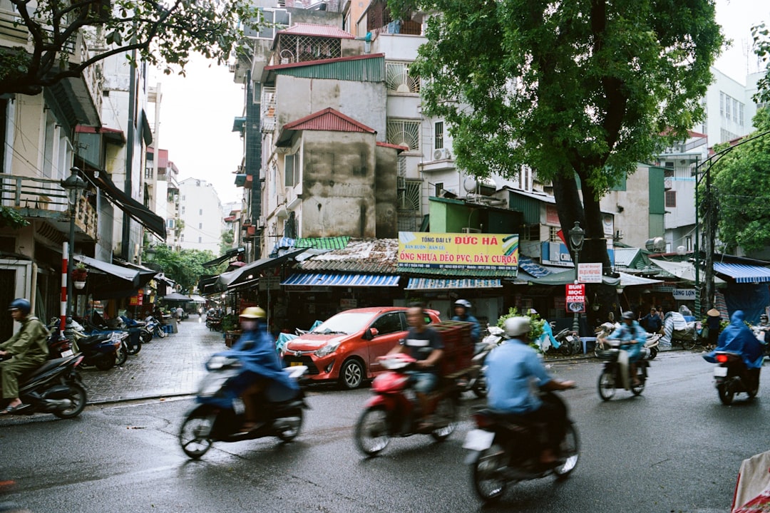 a group of people ride motorcycles down a street