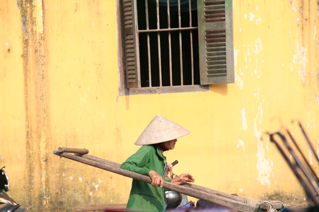 person wearing hat pushing cart during daytime