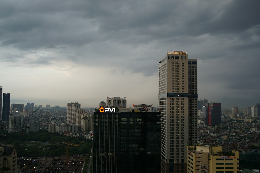 Cityscape with tall buildings under a dark, cloudy sky