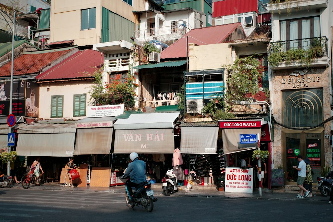 A man riding a motorcycle down a street next to tall buildings
