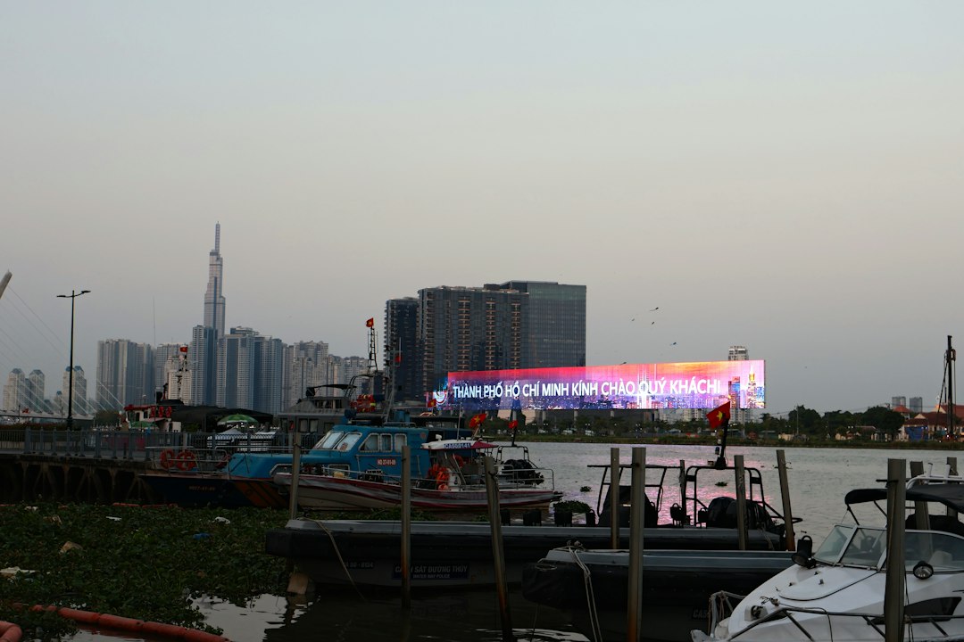 Boats docked on a river with a cityscape background